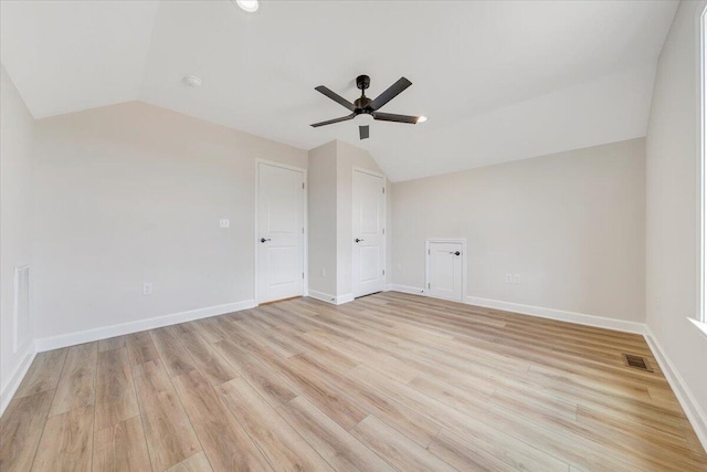 interior space with light wood-type flooring, visible vents, ceiling fan, and vaulted ceiling