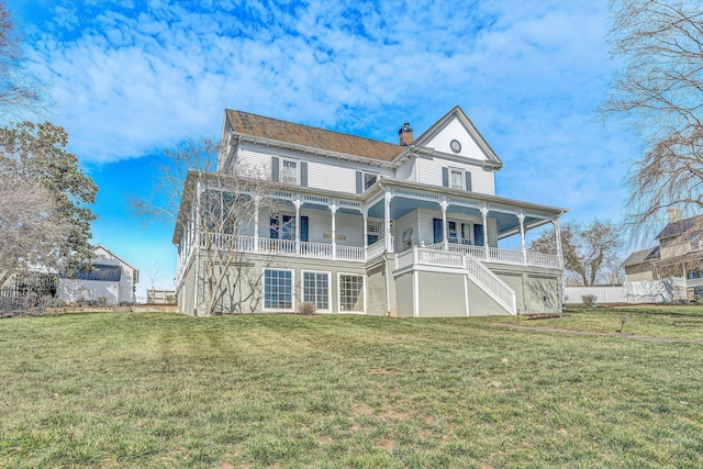 rear view of property featuring a yard, stairway, and a chimney