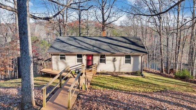 view of front of property featuring a front yard, a chimney, and a wooden deck