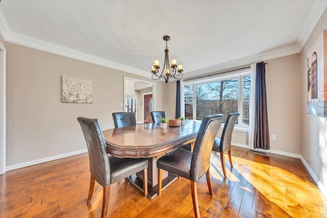 dining room featuring a chandelier, baseboards, and ornamental molding