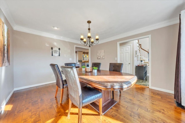 dining room featuring baseboards, wood-type flooring, and ornamental molding