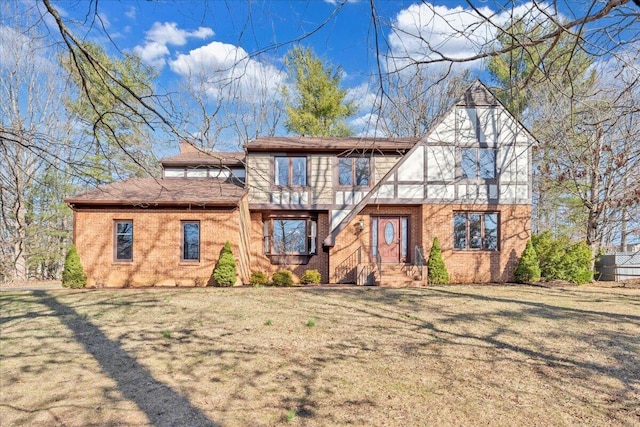 tudor house with brick siding and a front yard