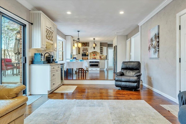 living room with wood finished floors, baseboards, recessed lighting, crown molding, and a textured wall