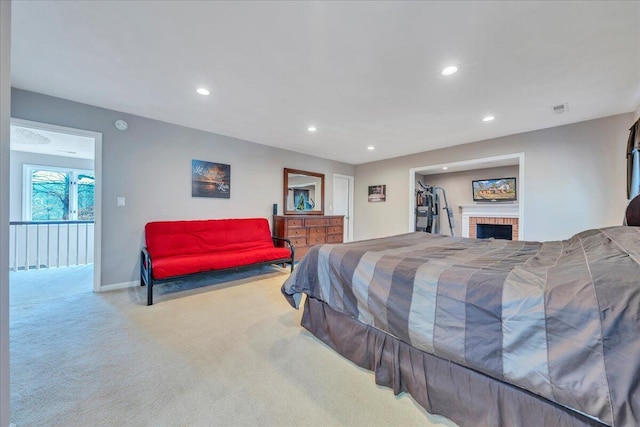 carpeted bedroom featuring a brick fireplace, recessed lighting, visible vents, and baseboards