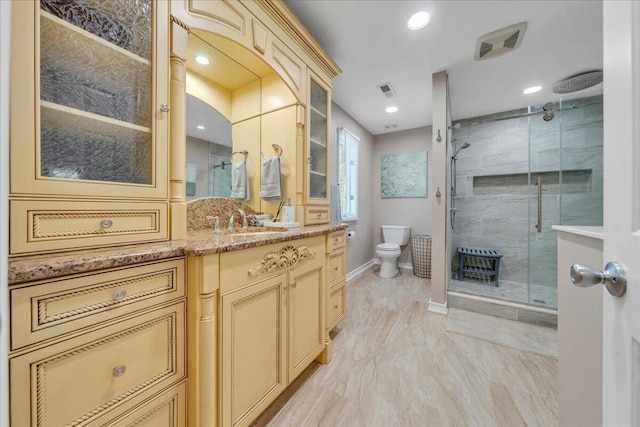 full bathroom with vanity, a shower stall, toilet, and baseboards