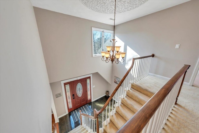 stairs featuring a chandelier, visible vents, carpet, and baseboards