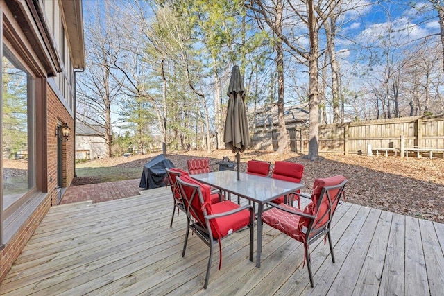 wooden terrace with outdoor dining space and fence