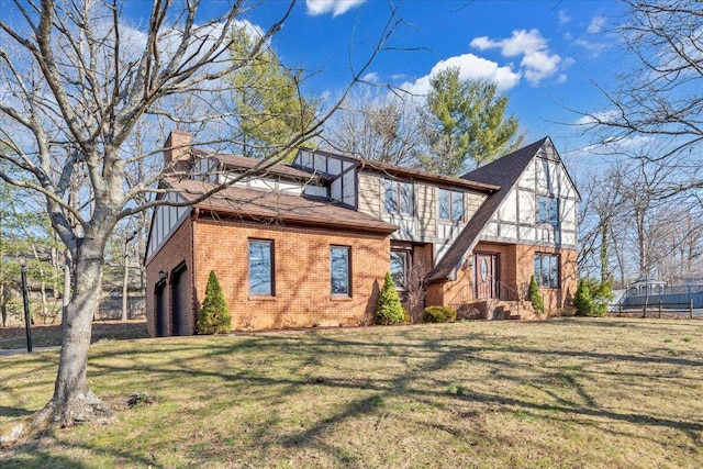 view of front of house with a shingled roof, a front lawn, brick siding, and a chimney