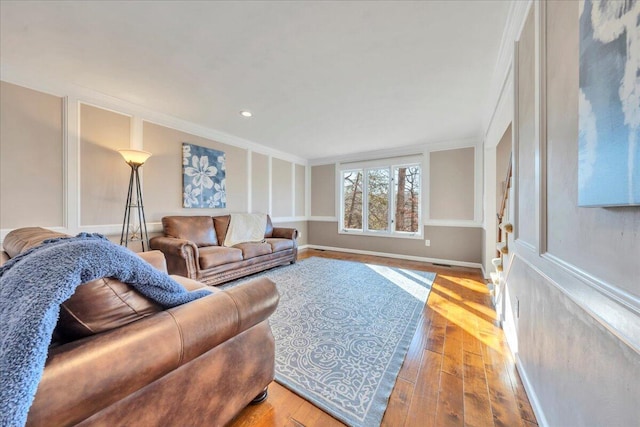 living room featuring recessed lighting, baseboards, wood-type flooring, and crown molding