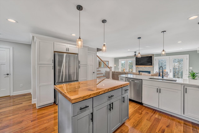 kitchen featuring recessed lighting, a sink, french doors, appliances with stainless steel finishes, and light wood-type flooring