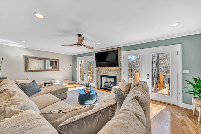 living area with baseboards, french doors, light wood-style flooring, and crown molding