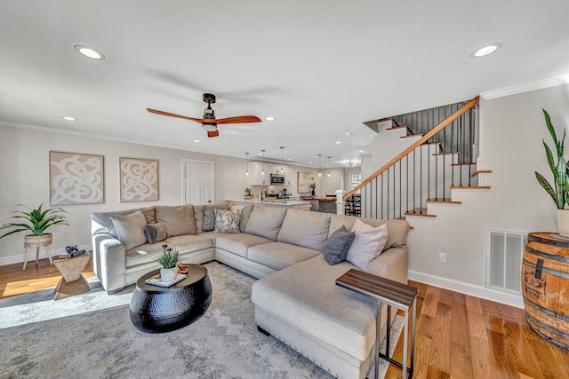 living area featuring baseboards, visible vents, wood finished floors, stairs, and recessed lighting