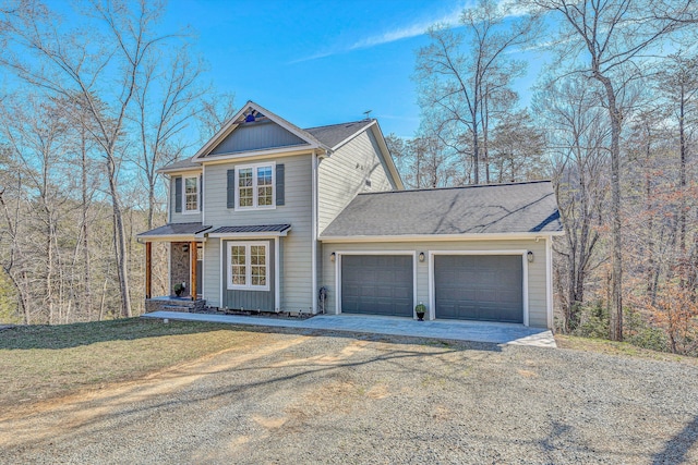 view of front of house with a garage, a front lawn, driveway, and board and batten siding