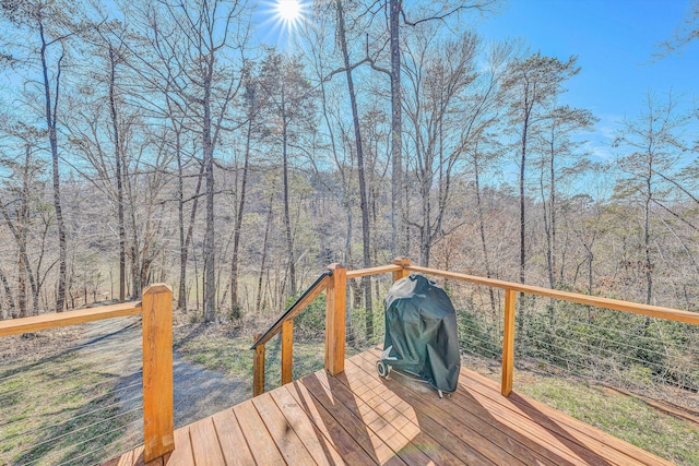 deck featuring a view of trees and area for grilling