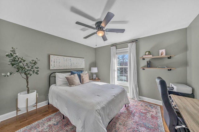 bedroom featuring wood finished floors, a ceiling fan, and baseboards