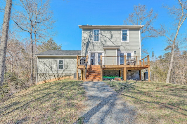 view of front of house featuring stairs, a front lawn, french doors, and a wooden deck