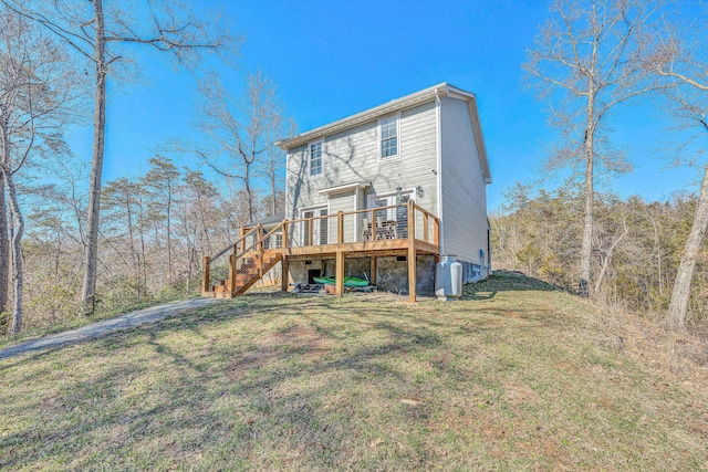 back of house featuring stairway, a deck, and a lawn