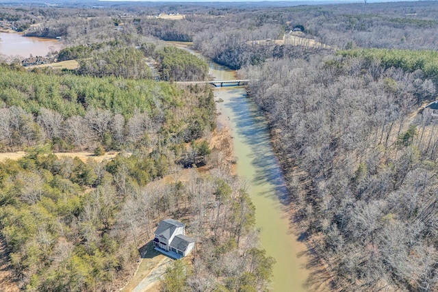 birds eye view of property featuring a forest view and a water view