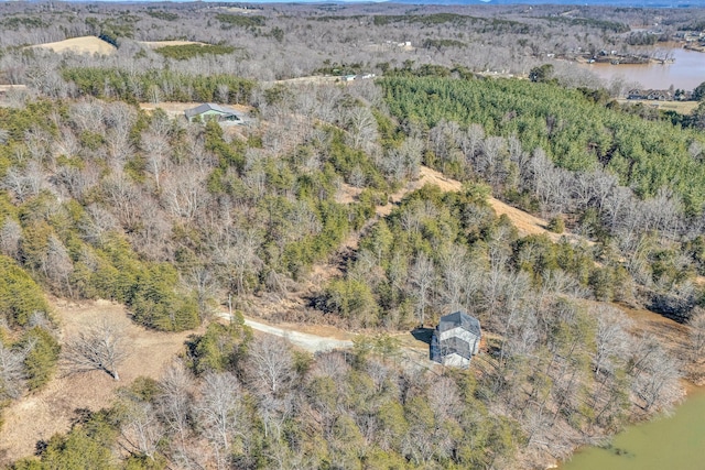 birds eye view of property with a water view and a wooded view