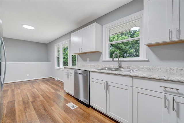 4438 Stonewall Rd NW, Roanoke, VA 24017 - kitchen featuring stainless steel dishwasher, a sink, light wood-type flooring, white cabinetry, and light stone countertops