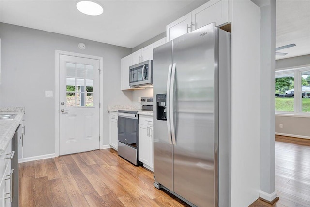4438 Stonewall Rd NW, Roanoke, VA 24017 - kitchen with stainless steel appliances, light wood-style floors, and white cabinetry