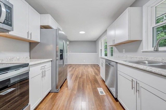 4438 Stonewall Rd NW, Roanoke, VA 24017 - kitchen with appliances with stainless steel finishes, a sink, light wood-type flooring, white cabinets, and recessed lighting