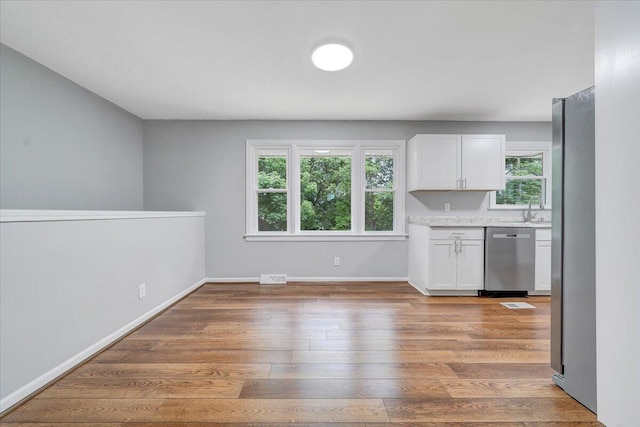 4438 Stonewall Rd NW, Roanoke, VA 24017 - kitchen featuring stainless steel appliances, a sink, white cabinetry, light countertops, and light wood finished floors