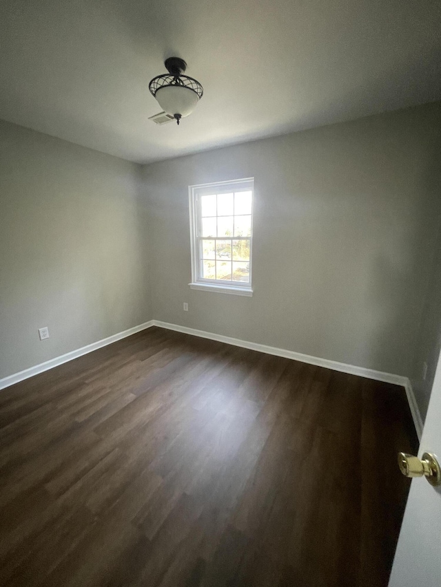 unfurnished room with dark wood-style floors and baseboards