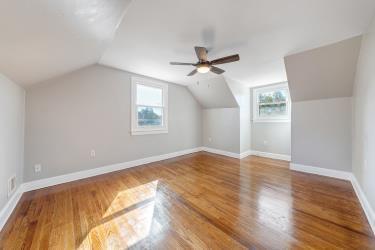 bonus room with baseboards, a wealth of natural light, and wood finished floors