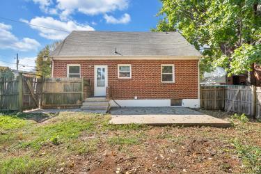 back of house featuring entry steps, brick siding, a fenced backyard, and a patio