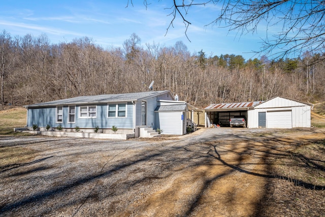 view of front of home with a garage, driveway, and an outdoor structure