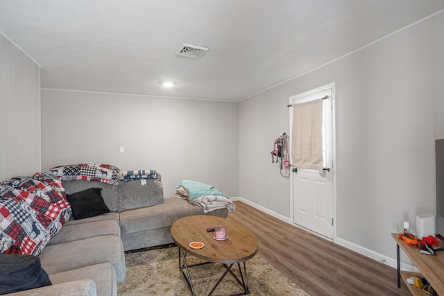 living area featuring wood finished floors, visible vents, and baseboards