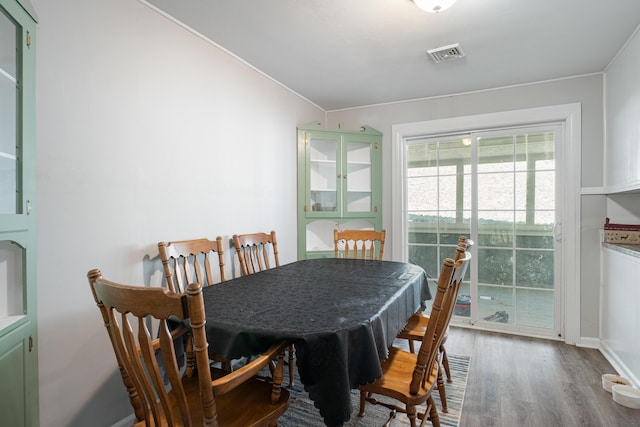 dining area with wood finished floors, visible vents, and baseboards