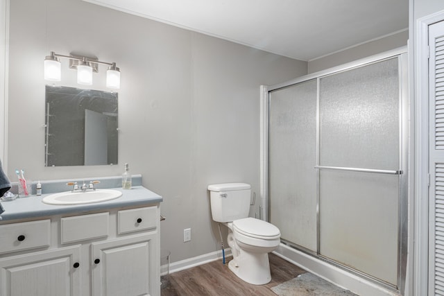 full bathroom featuring a stall shower, vanity, toilet, and wood finished floors