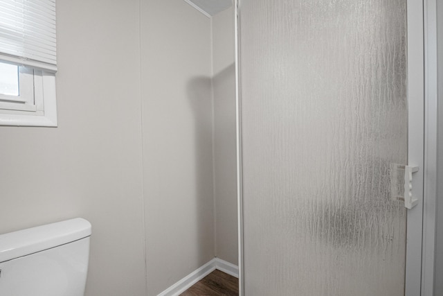 bathroom featuring toilet, baseboards, and wood finished floors