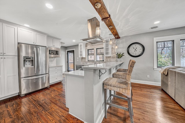 kitchen with tasteful backsplash, visible vents, glass insert cabinets, a peninsula, and stainless steel appliances