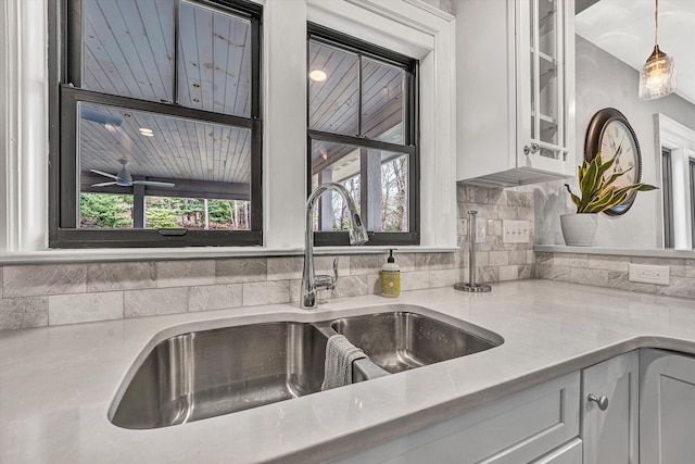 kitchen with white cabinetry, light countertops, a wealth of natural light, and a sink