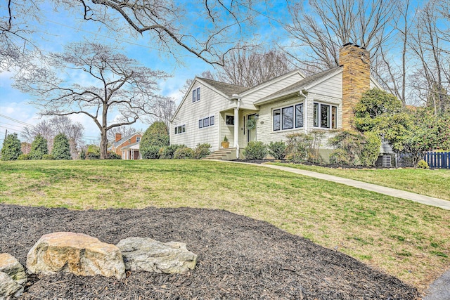 view of front of house featuring a chimney and a front yard