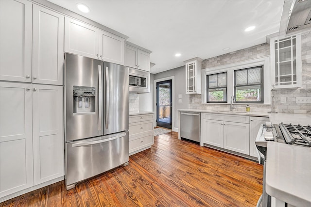 kitchen with decorative backsplash, light countertops, dark wood-style flooring, and appliances with stainless steel finishes