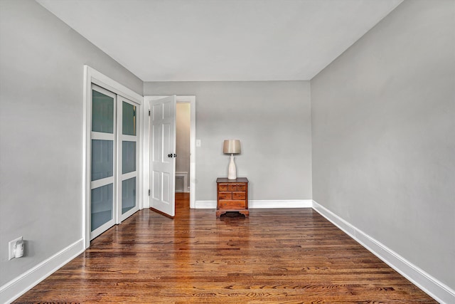 unfurnished room featuring baseboards and wood finished floors