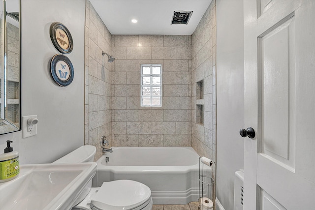 bathroom featuring shower / bathing tub combination, toilet, and a sink