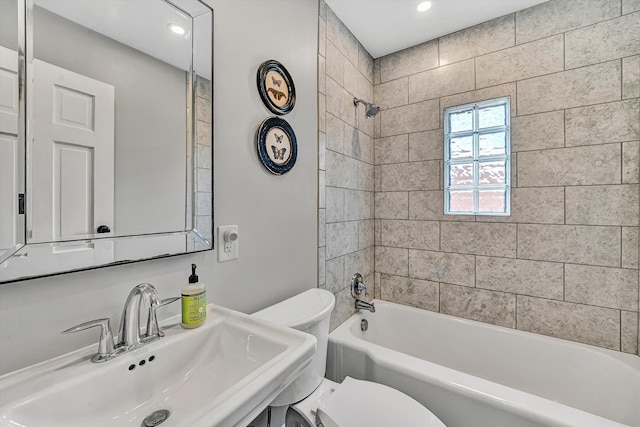 bathroom featuring shower / washtub combination, toilet, and a sink