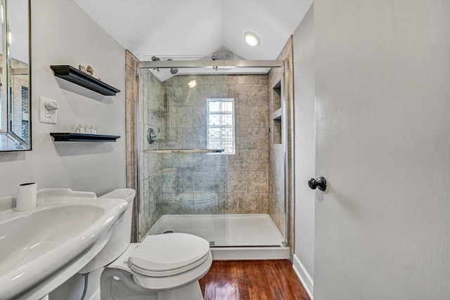 bathroom with a sink, a stall shower, toilet, and wood finished floors