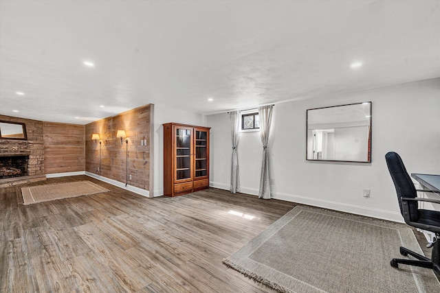 unfurnished office featuring recessed lighting, a fireplace, and wood finished floors