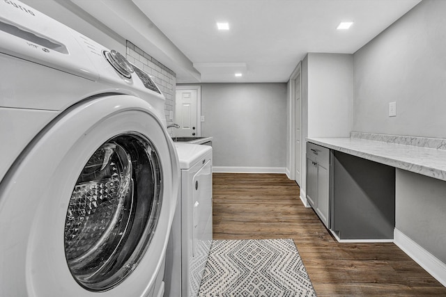 laundry room featuring laundry area, baseboards, dark wood-type flooring, and washer and clothes dryer