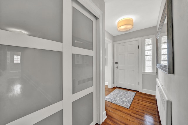 foyer featuring radiator, baseboards, and wood finished floors