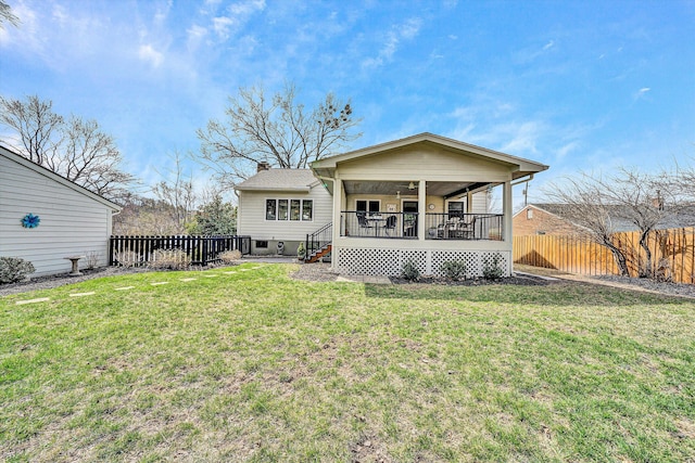 back of property with a lawn, a porch, a fenced backyard, and a chimney