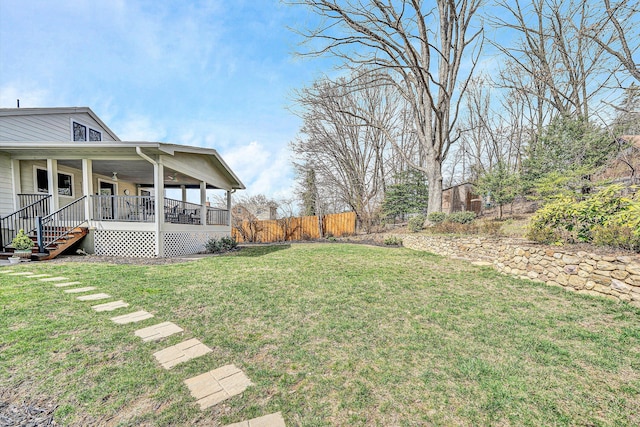 view of yard with fence and covered porch