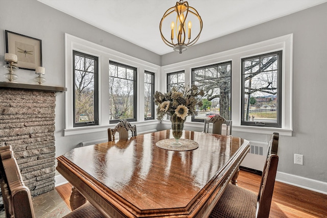 dining area featuring plenty of natural light, wood finished floors, baseboards, and a chandelier