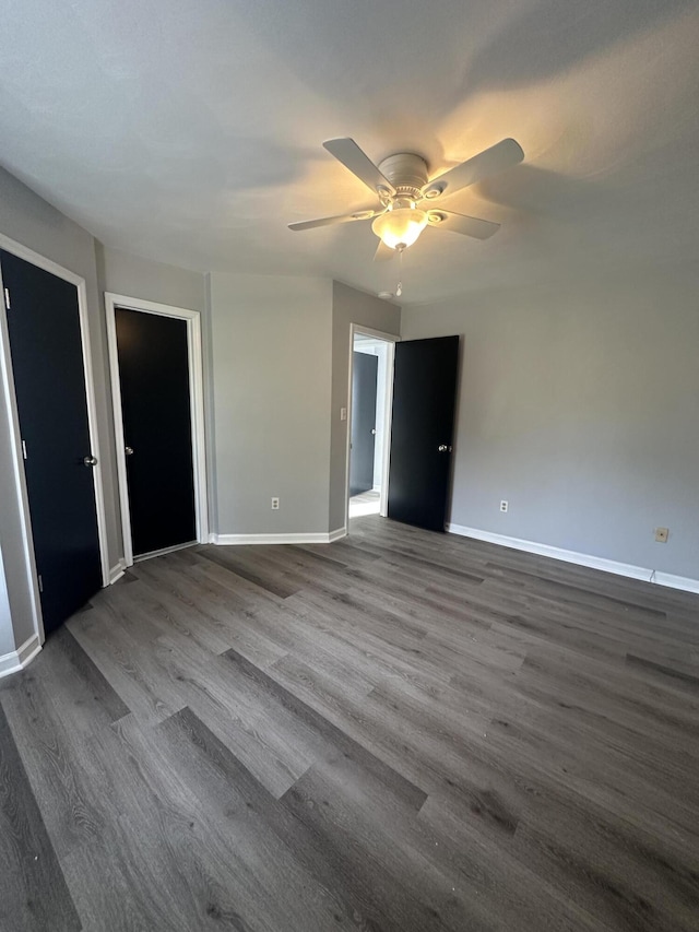 unfurnished bedroom featuring ceiling fan, dark wood finished floors, and baseboards